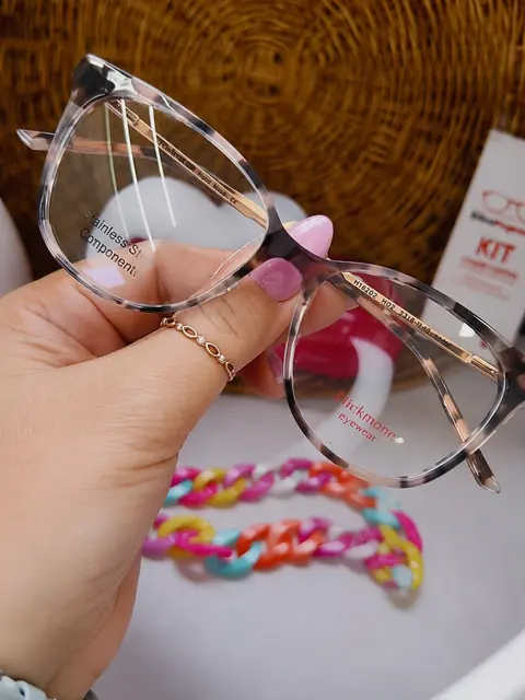 Armação feminina em acetato tartaruga translúcido segurada pela mão